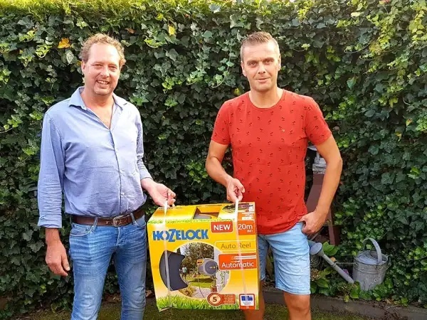 Eddie Slomp overhandigt de tuinslag met houder aan Dennis Kuiper